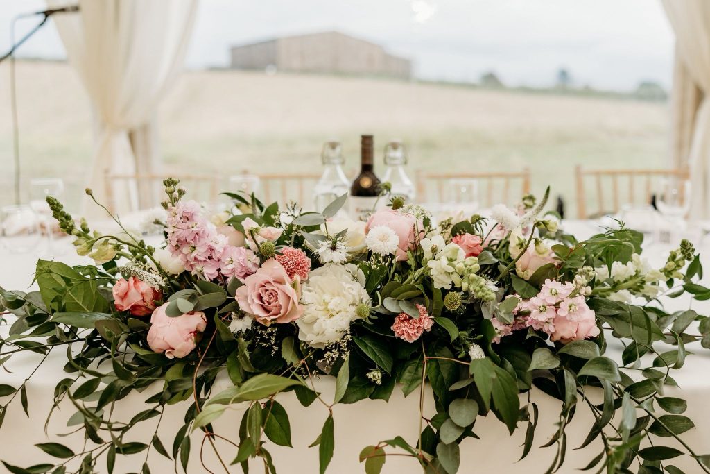 Pale pinks and white floral top table arrangement by The Flowers of May