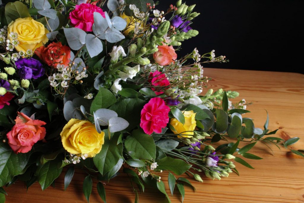 Bright colourful coffin spray by The Flowers of May